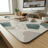 A desk mat with sage green abstract blocks, cream space, gray stone-like shapes, fine topographic contour lines, and small branch details.