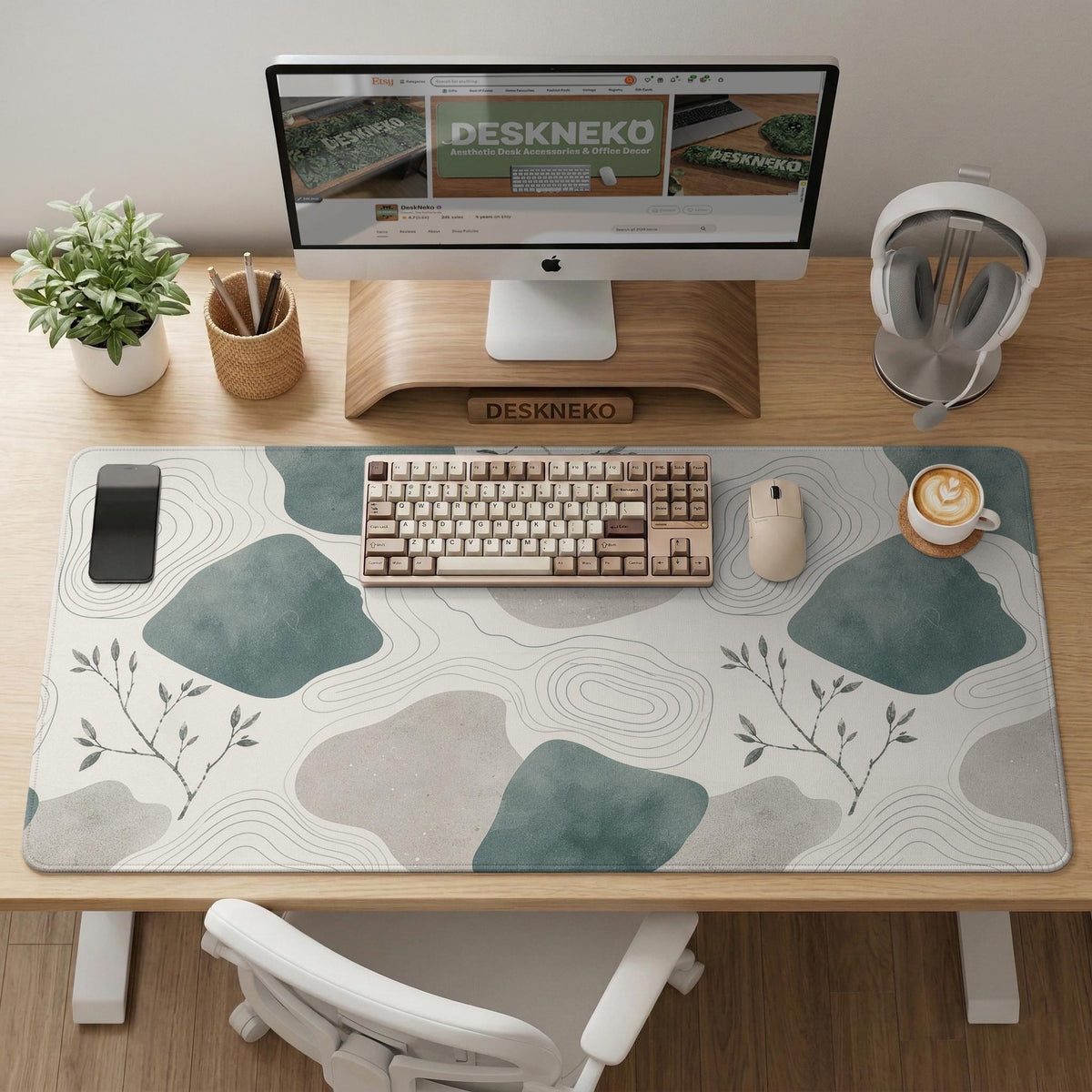 A desk mat with sage green abstract blocks, cream space, gray stone-like shapes, fine topographic contour lines, and small branch details.