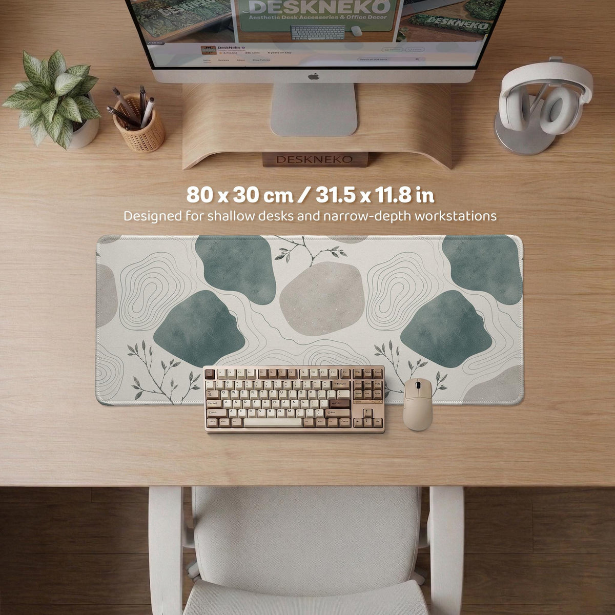 A desk mat with sage green abstract blocks, cream space, gray stone-like shapes, fine topographic contour lines, and small branch details.