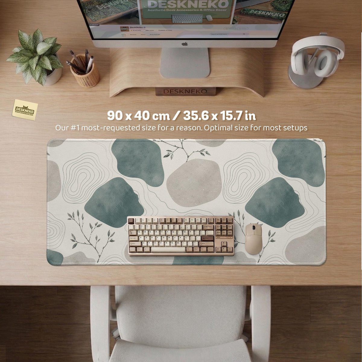 A desk mat with sage green abstract blocks, cream space, gray stone-like shapes, fine topographic contour lines, and small branch details.