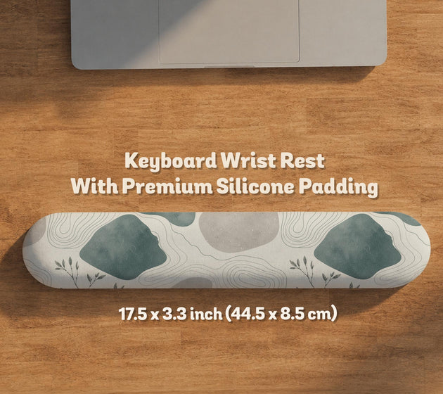 Sage green ergonomic mousepad and keyboard wrist rest with abstract shapes, soft gray details, cream space, topographic contour lines, and leafy branch accents.