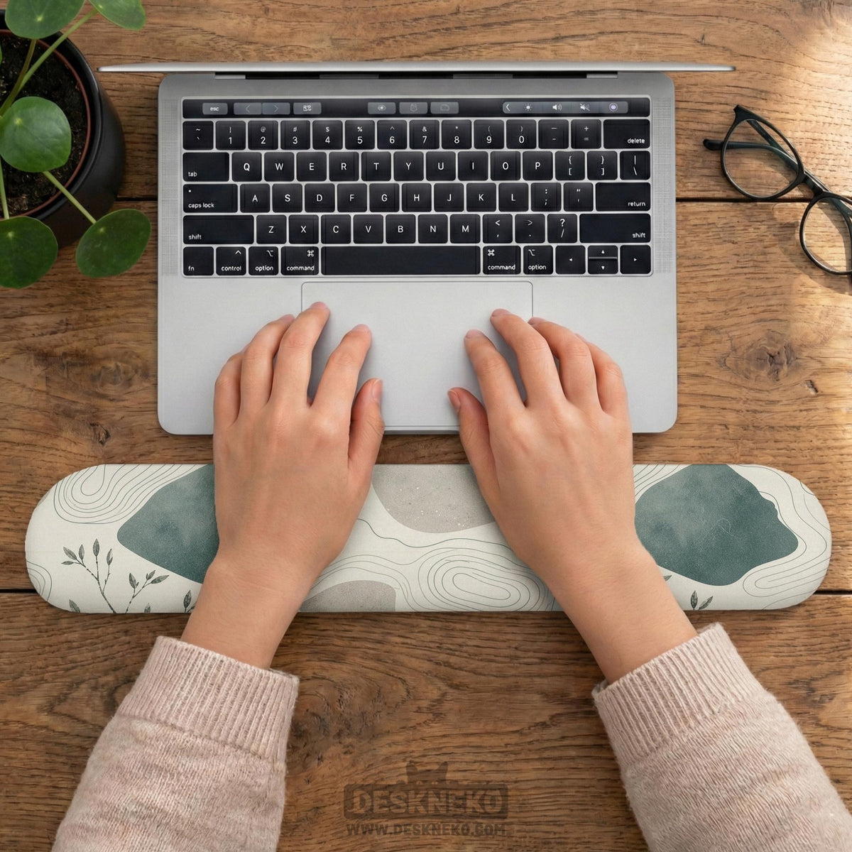 Sage green ergonomic mousepad and keyboard wrist rest with abstract shapes, soft gray details, cream space, topographic contour lines, and leafy branch accents.