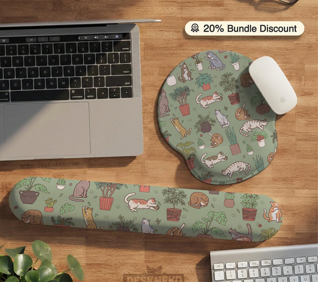 Sage green desk mat with a pattern of lounging cats, leafy plants, cactus pots, and earthy botanical details.