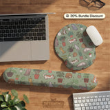 Sage green desk mat with a pattern of lounging cats, leafy plants, cactus pots, and earthy botanical details.