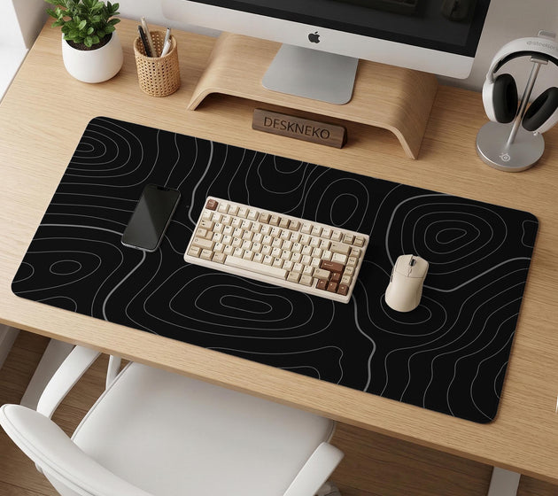 Black desk mat with a thin gray topographic contour line pattern.