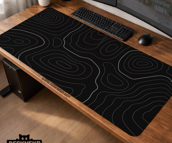 Black desk mat with a thin gray topographic contour line pattern.