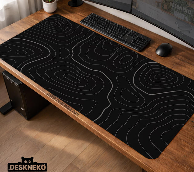 Black desk mat with a thin gray topographic contour line pattern.