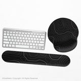 Black mousepad with a gray topographic contour line pattern shown with matching keyboard wrist rest options.