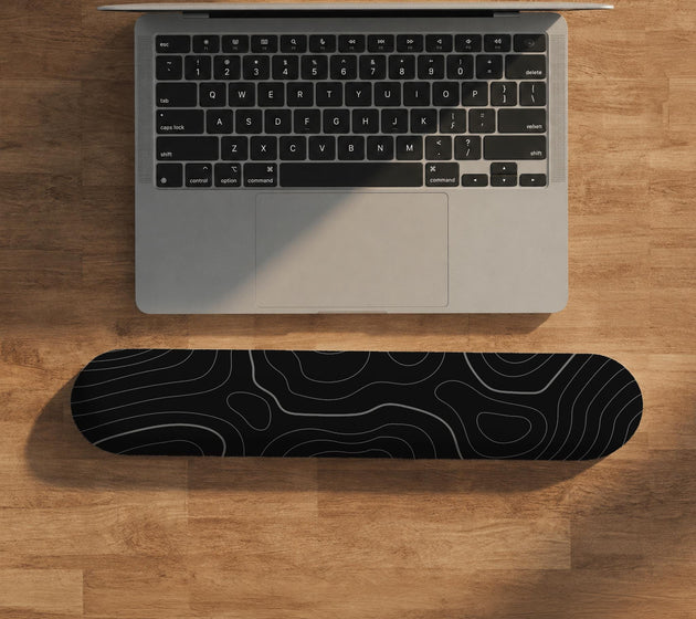 Black mousepad with a gray topographic contour line pattern shown with matching keyboard wrist rest options.