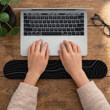 Black mousepad with a gray topographic contour line pattern shown with matching keyboard wrist rest options.