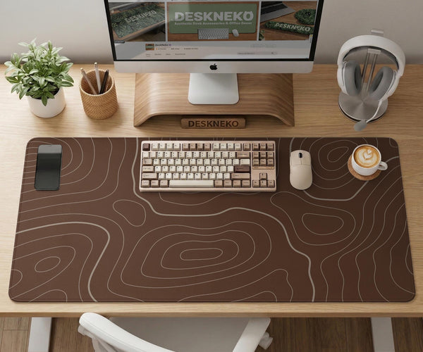 Brown desk mat with a repeating topographic contour line pattern in a neutral earth tone design.