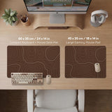 Brown desk mat with a repeating topographic contour line pattern in a neutral earth tone design.