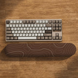 Brown mousepad and keyboard wrist rest with a topographic contour-line pattern.
