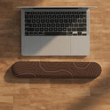 Brown mousepad and keyboard wrist rest with a topographic contour-line pattern.