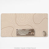Beige desk mat with soft brown topographic contour lines on a neutral background.