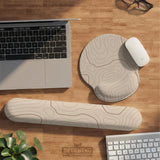 Beige mousepad and keyboard wrist rest with a topographic line pattern shown in a neutral desk setup.
