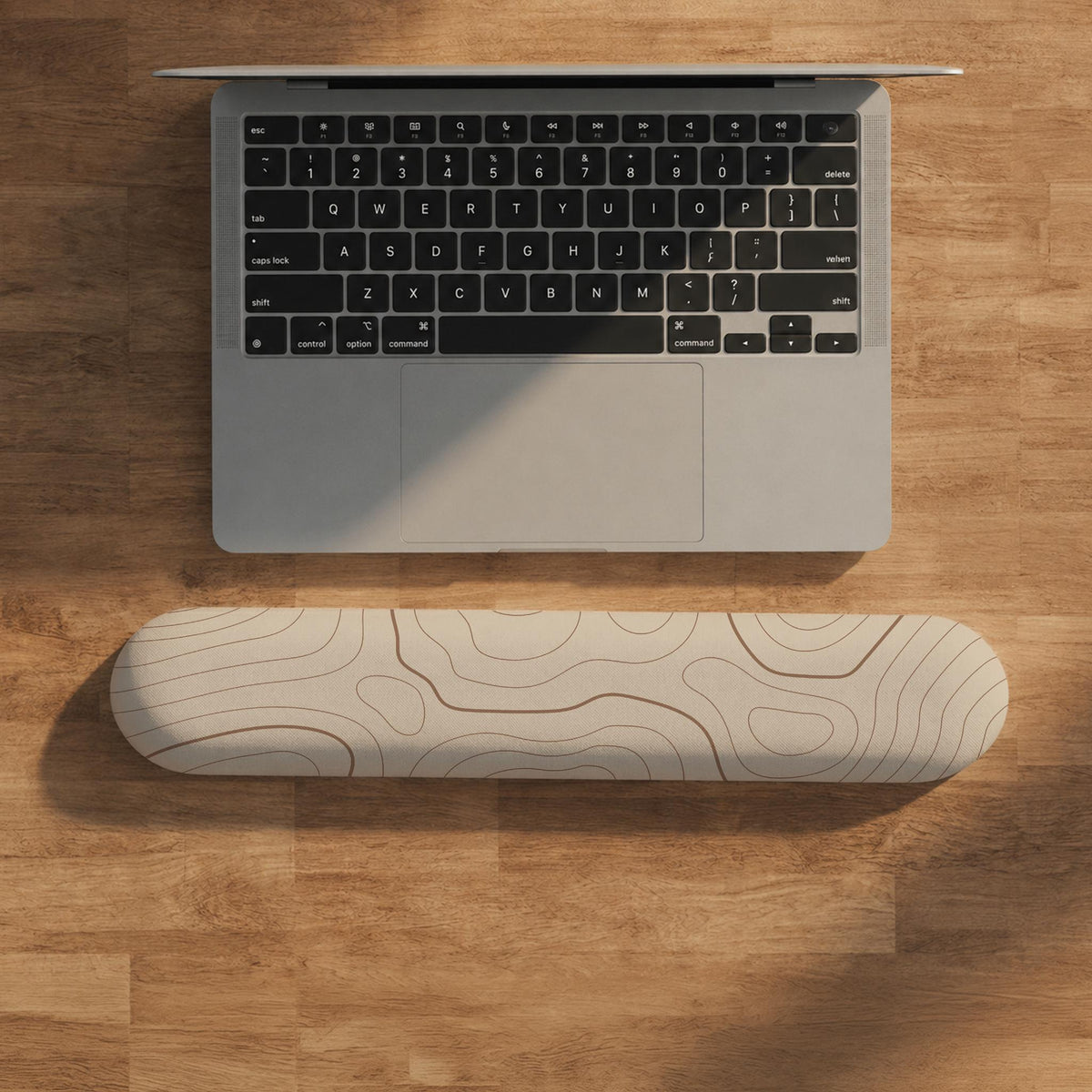 Beige mousepad and keyboard wrist rest with a topographic line pattern shown in a neutral desk setup.