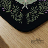 Black mahjong table mat with luna moths, purple flowers, soft green leaves, copper moons, and small star details.