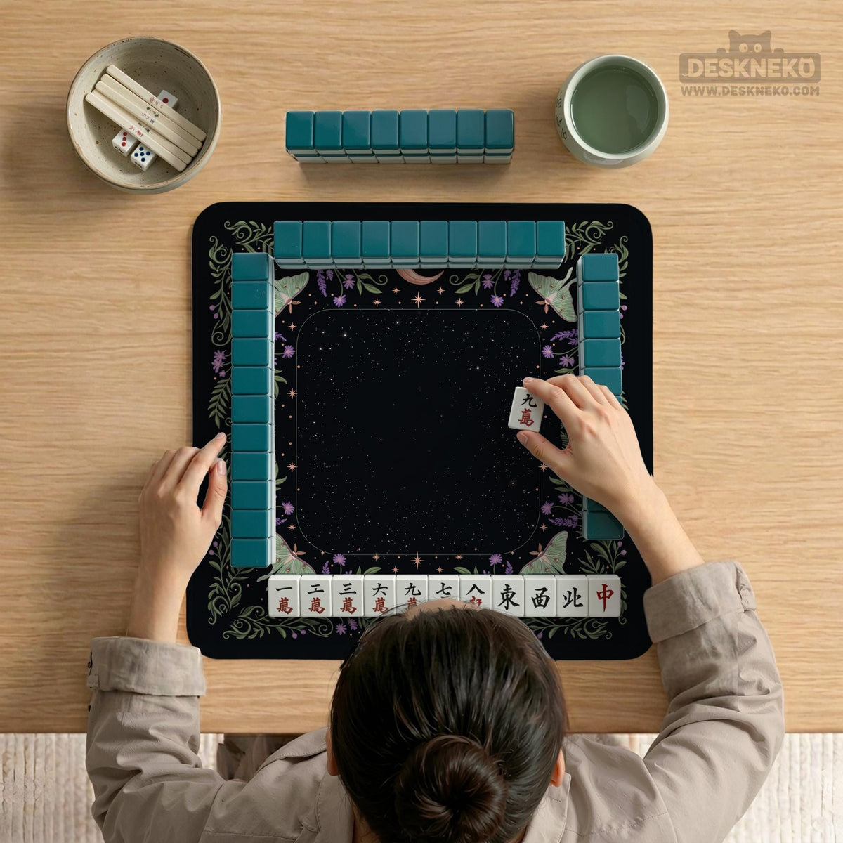 Black mahjong table mat with luna moths, purple flowers, soft green leaves, copper moons, and small star details.