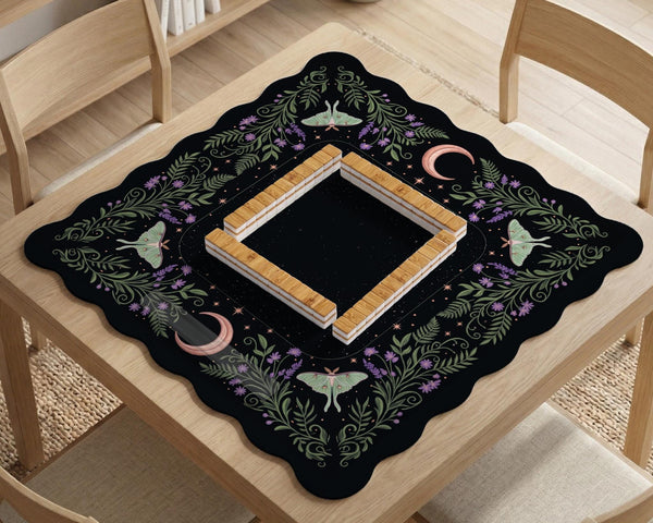 Black mahjong table mat with luna moths, purple flowers, soft green leaves, copper moons, and small star details.