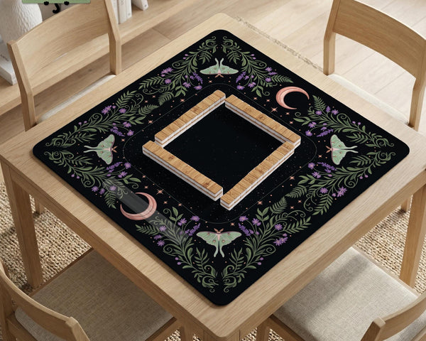 Black mahjong table mat with luna moths, purple flowers, soft green leaves, copper moons, and small star details.