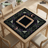 Black mahjong table mat with luna moths, purple flowers, soft green leaves, copper moons, and small star details.
