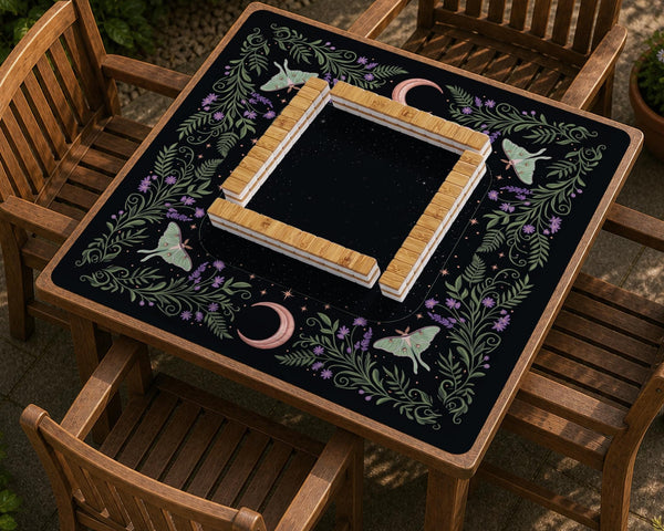 Black mahjong table mat with luna moths, purple flowers, soft green leaves, copper moons, and small star details.