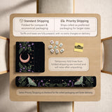 Black mahjong table mat with luna moths, purple flowers, soft green leaves, copper moons, and small star details.