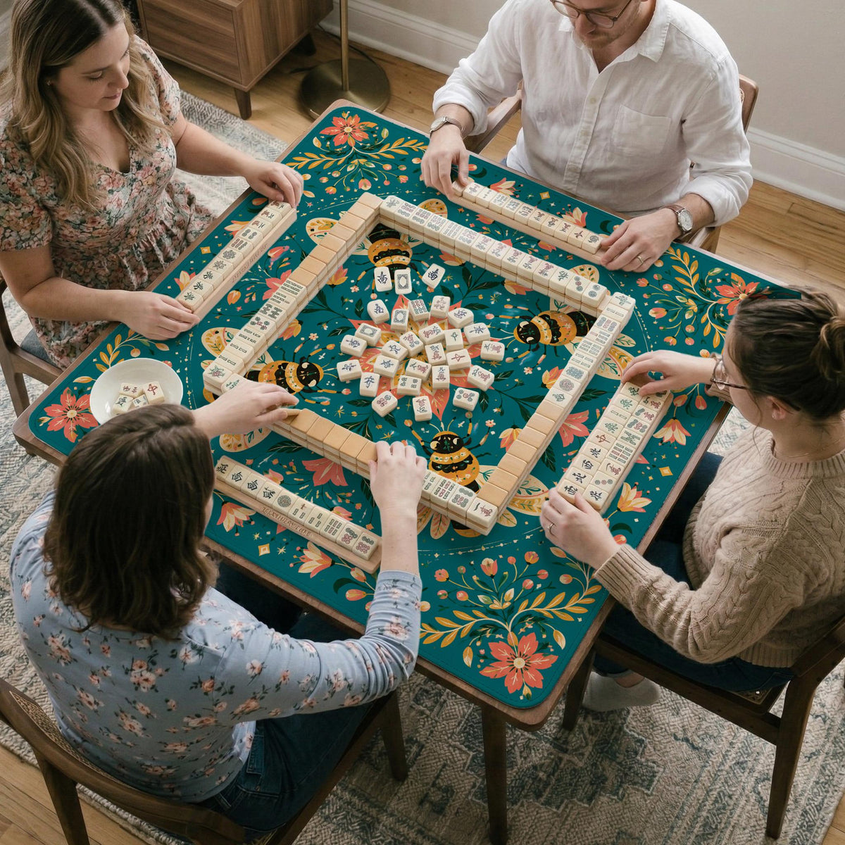 Green mahjong mat with a botanical bee and floral mandala design in teal, coral, cream, and gold.