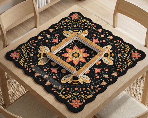 Black mahjong mat with a symmetrical botanical design, coral flowers, golden leaves, and small bees.