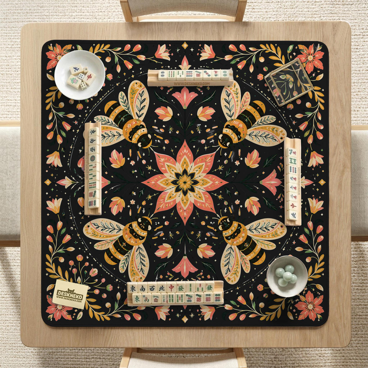 Black mahjong mat with a symmetrical botanical design, coral flowers, golden leaves, and small bees.