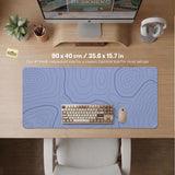 A pastel blue mousepad with an abstract topographic contour line pattern.