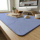 A pastel blue mousepad with an abstract topographic contour line pattern.