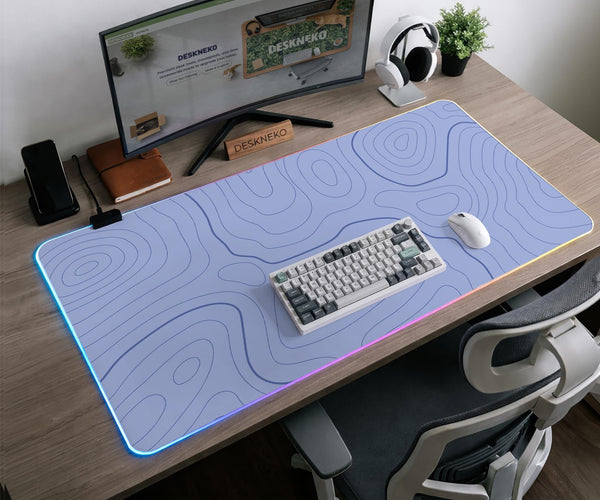 A pastel blue mousepad with an abstract topographic contour line pattern.
