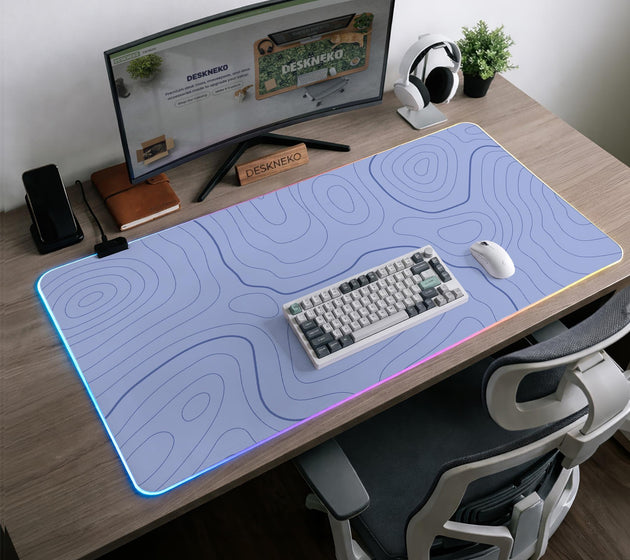 A pastel blue mousepad with an abstract topographic contour line pattern.