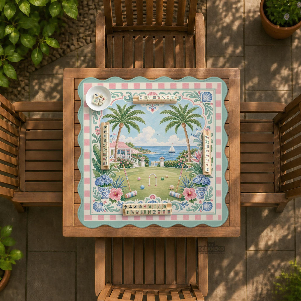Pastel mahjong mat with a pink gingham border, seashells, hydrangea pots, palm trees, croquet details, and a coastal garden scene.