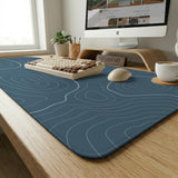 A slate blue desk mat with thin contour line map art on a light background.
