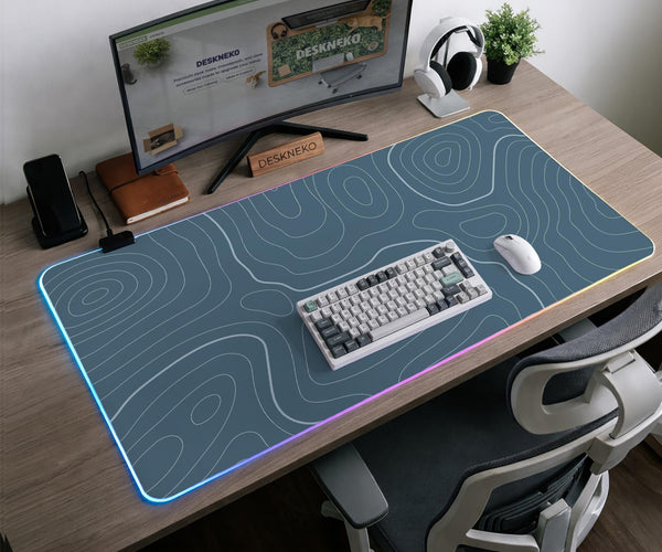 Blue mousepad with a topographic line pattern on a slate background.