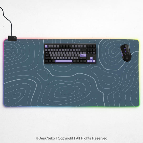 Blue mousepad with a topographic line pattern on a slate background.