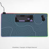 Blue mousepad with a topographic line pattern on a slate background.
