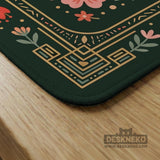 Dark green square mahjong mat with floral branches, small red blossoms, gold line details, and a large moth in the center.