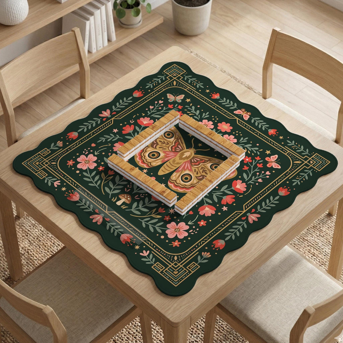 Dark green square mahjong mat with floral branches, small red blossoms, gold line details, and a large moth in the center.
