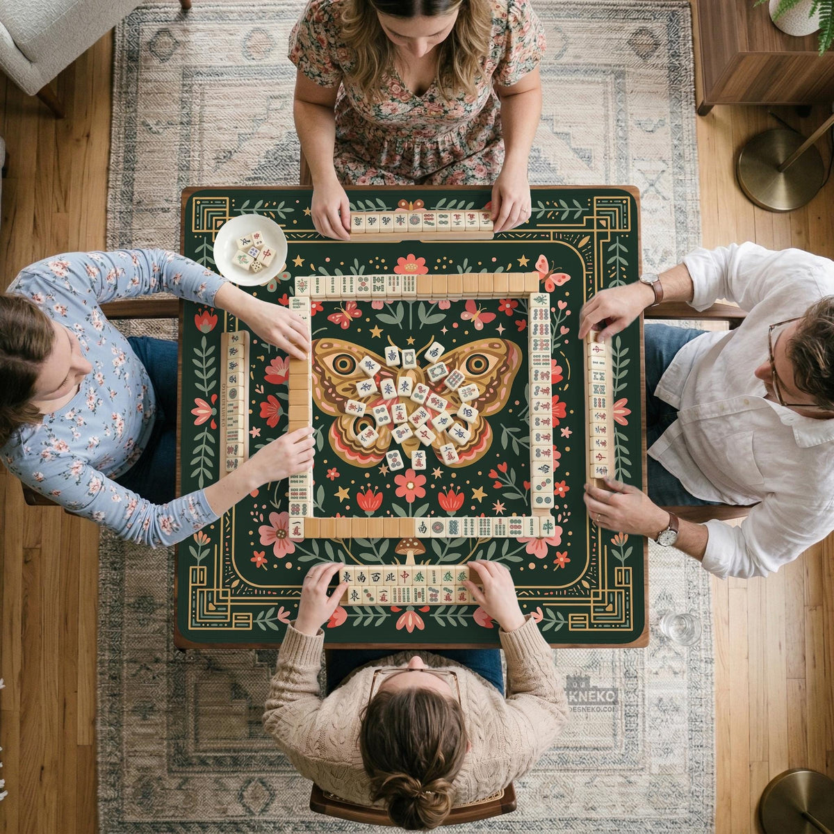 Dark green square mahjong mat with floral branches, small red blossoms, gold line details, and a large moth in the center.