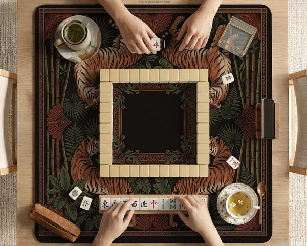 Black square mahjong mat with mirrored tiger faces, bamboo, dark tropical leaves, ornate border details, and orange accents.