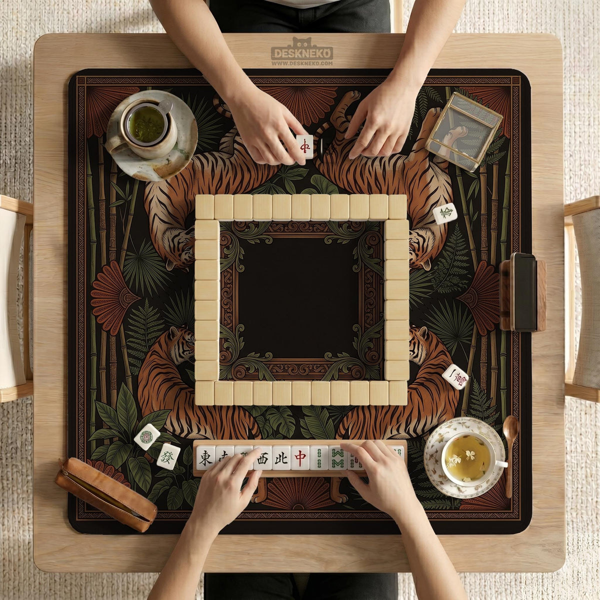 Black square mahjong mat with mirrored tiger faces, bamboo, dark tropical leaves, ornate border details, and orange accents.