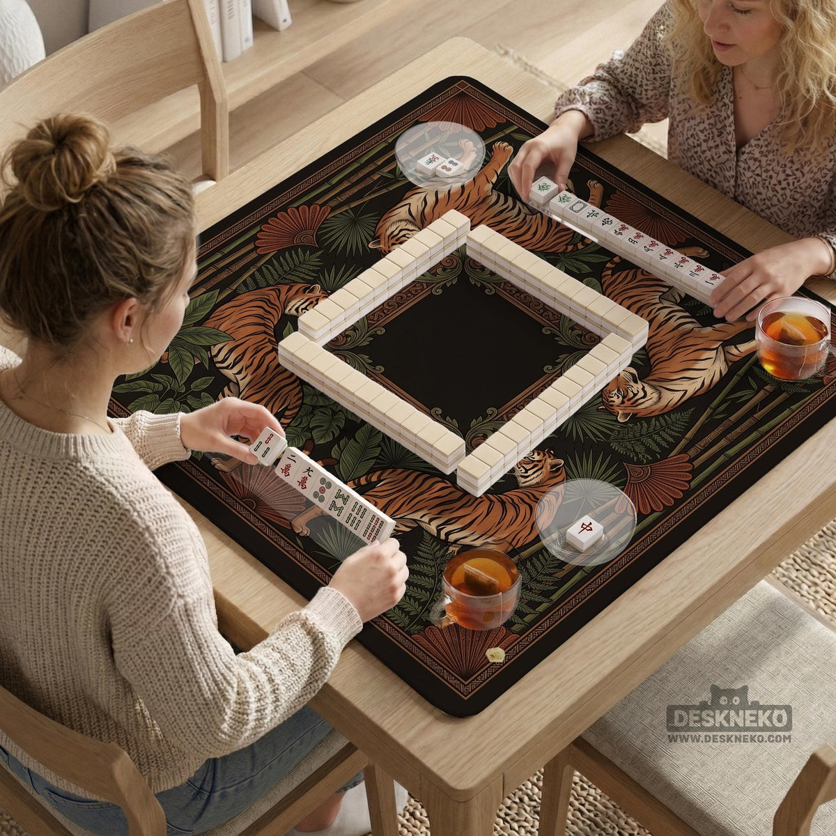 Black square mahjong mat with mirrored tiger faces, bamboo, dark tropical leaves, ornate border details, and orange accents.