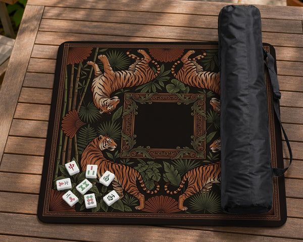 Black square mahjong mat with mirrored tiger faces, bamboo, dark tropical leaves, ornate border details, and orange accents.
