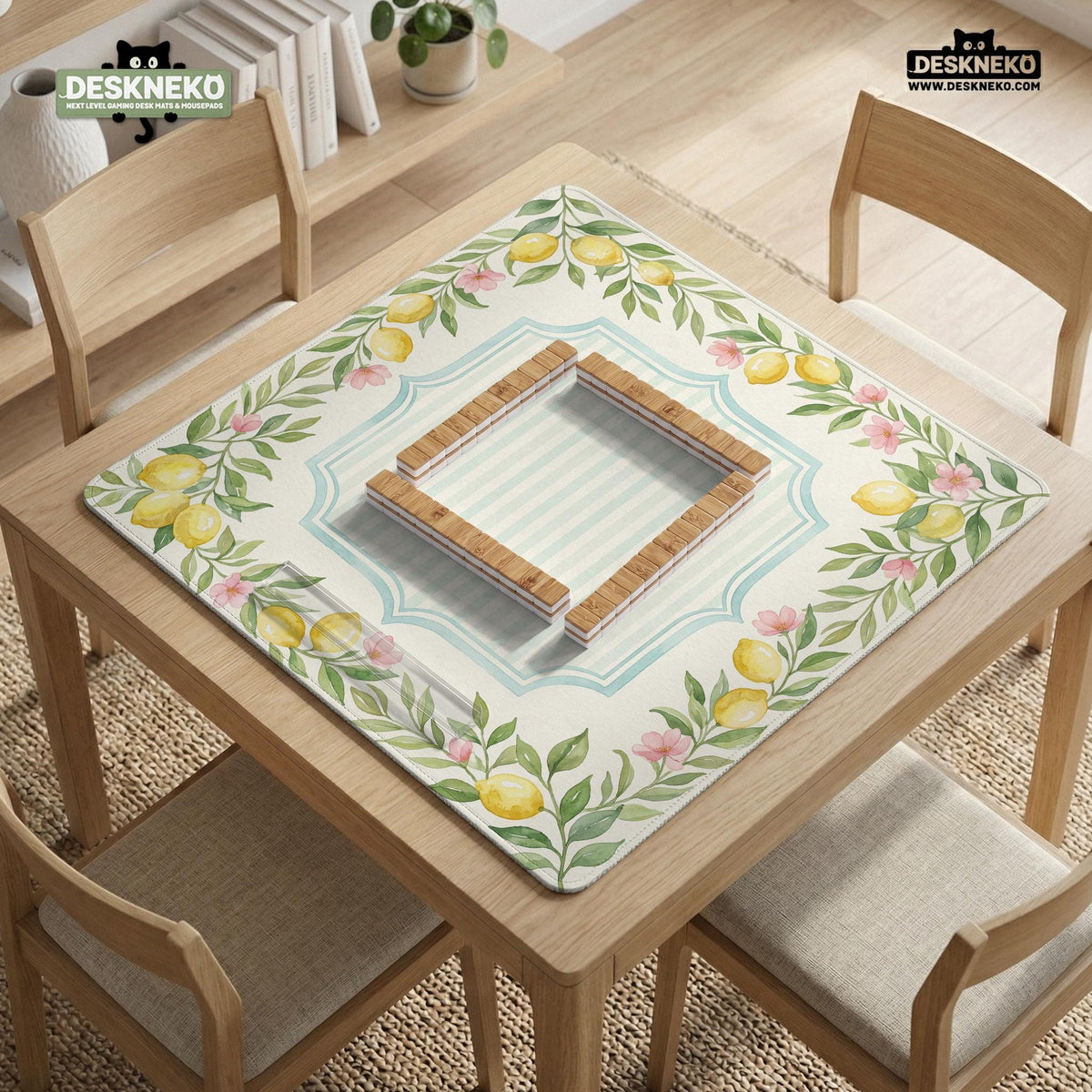Square yellow mahjong mat with a citrus garden border, green vines, pink blossoms, aqua accents, and a plain center play area.