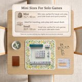 Square yellow mahjong mat with a citrus garden border, green vines, pink blossoms, aqua accents, and a plain center play area.