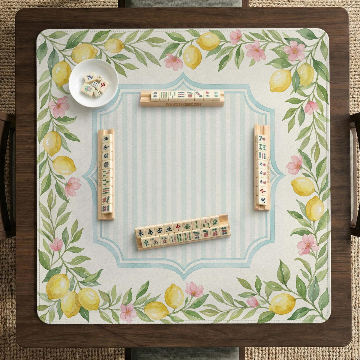 Square yellow mahjong mat with a citrus garden border, green vines, pink blossoms, aqua accents, and a plain center play area.